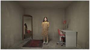 A young girl stands in a miniaturized bedroom.